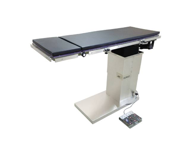 電動油圧式の動物用手術台「ヒューベス HUMAX FOP-EH1500」。透明ポリカーボネート製の天板、700mmから1000mmまでの昇降範囲、多角度調整機能を備え、フットスイッチで操作可能。大型犬にも対応。